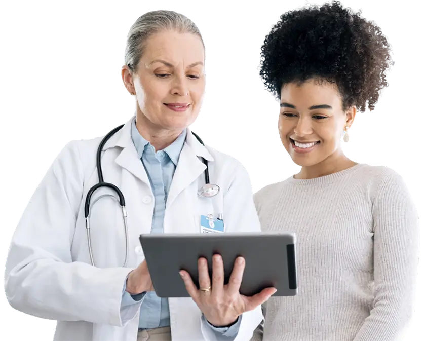 A doctor and patient reviewing information together on a tablet in a clinical setting.