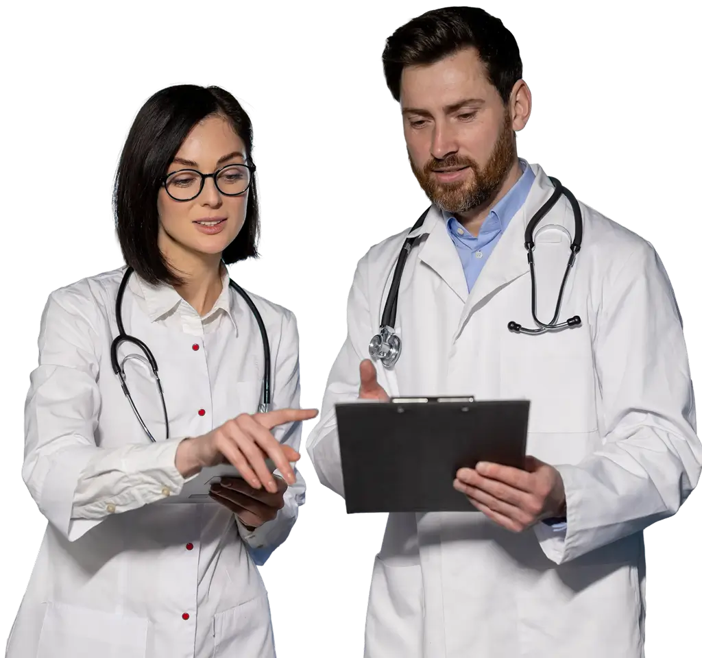 Two doctors stand side by side, holding a tablet and discussing medical information.
