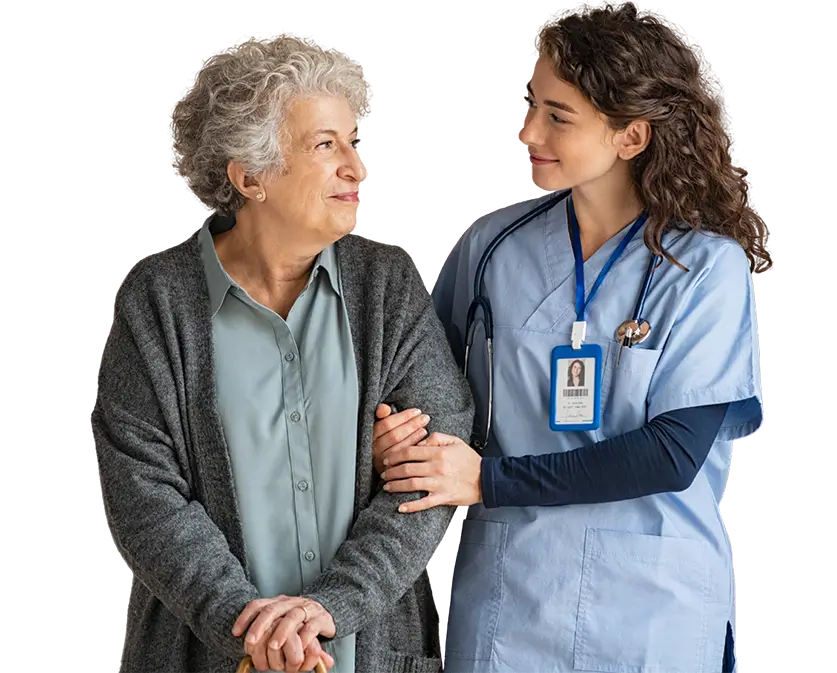 A nurse stands beside an elderly woman, both smiling and engaged in conversation in a healthcare setting.