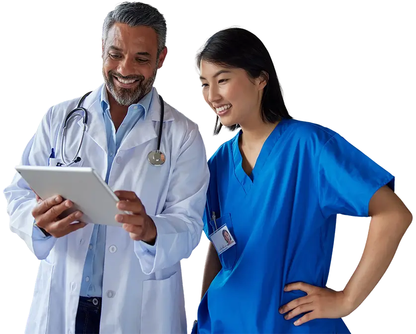 A doctor and nurse examine a tablet together, discussing patient information in a clinical setting.